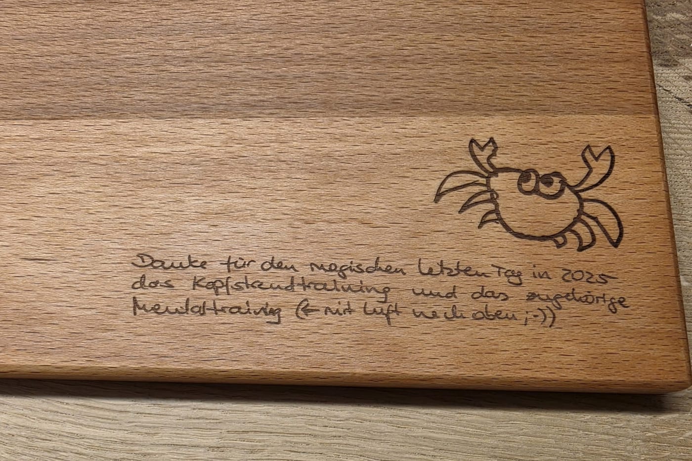 Nahaufnahme eines Schneidebretts aus Buchenholz mit der gravierten Zeichnung und dem gravierten Satz von der Karte.